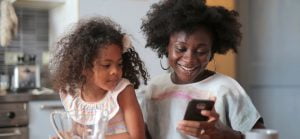 mum and daughter looking at smartphone