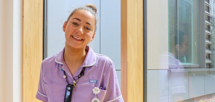 nurse in purple uniform smiling