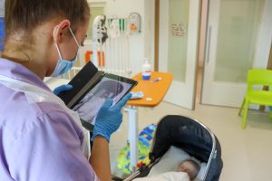 nurse using ipad to take picture of baby in a pram