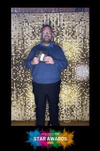 James smiles in front of a gold curtain