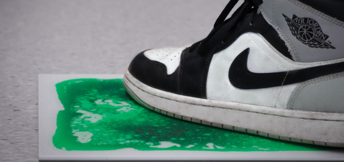 A black and white nike shoe on a green tile