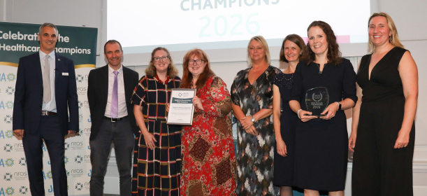 The team smile as they receive their award on stage