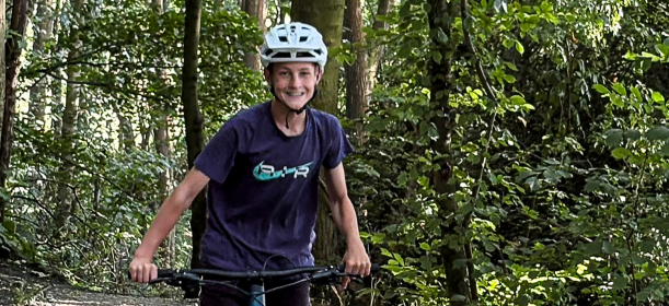 Harry smiles whilst cycling in the woods