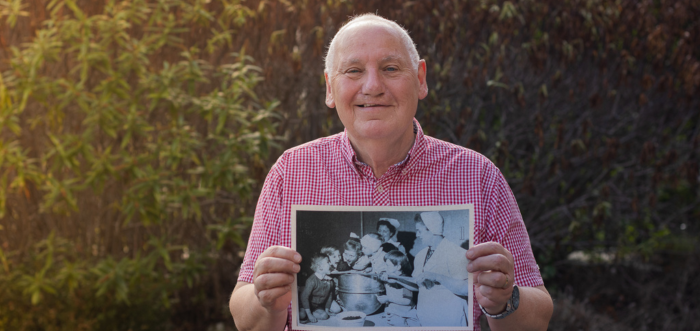 Paul smiles whilst holding an old photo of himself at Sheffield Children's